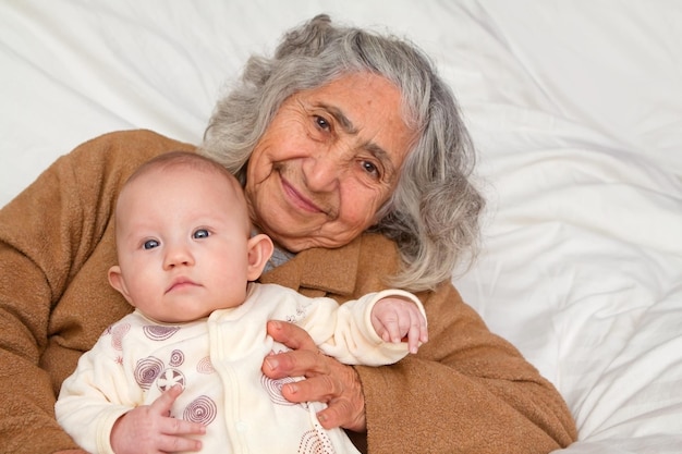 Foto retrato de la abuela con la niña acostada en la cama en casa