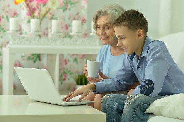 Retrato de abuela y niño con laptop en la habitación