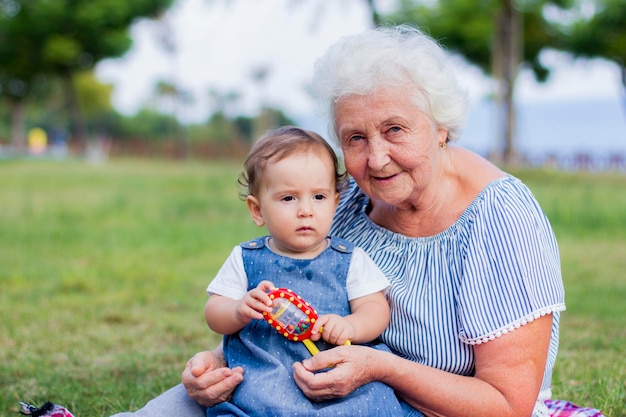 Foto retrato de la abuela sentada con su nieta en el parque