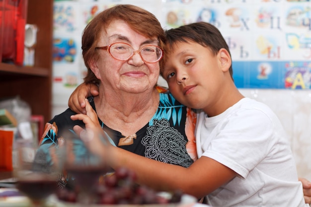 Retrato de una abuela sonriente con su nieto en casa