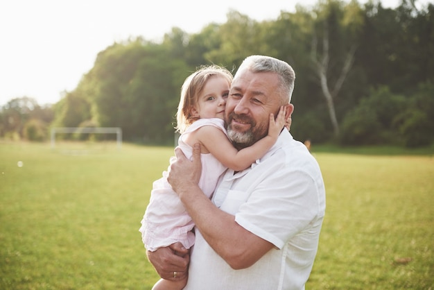 Retrato de abuelo con nieta, relajarse juntos en el parque