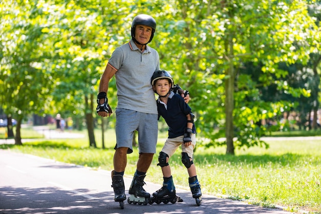 Retrato de abuelo y nieto patinando en el parque