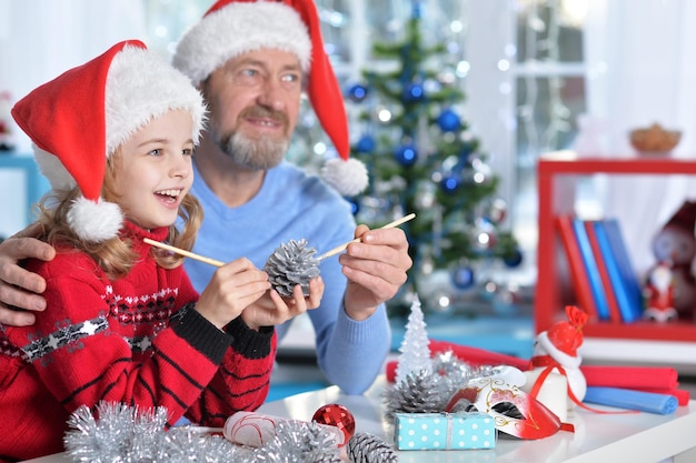 Retrato de abuelo con niña preparándose para Navidad