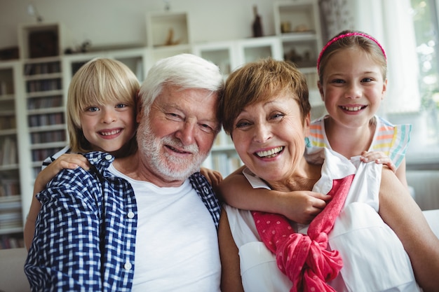 Retrato de abuelos sonriendo con sus nietos