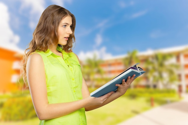 Retrato de una adolescente alegre con un libro