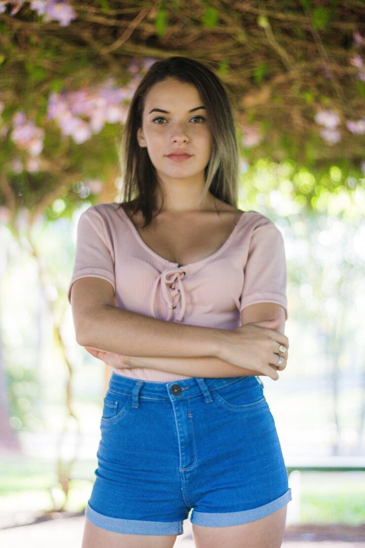 Foto retrato de una adolescente con los brazos cruzados de pie en el parque