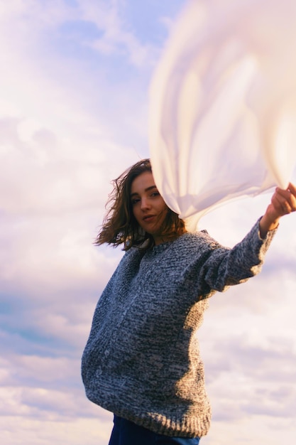 Foto retrato de una adolescente con una bufanda contra el cielo