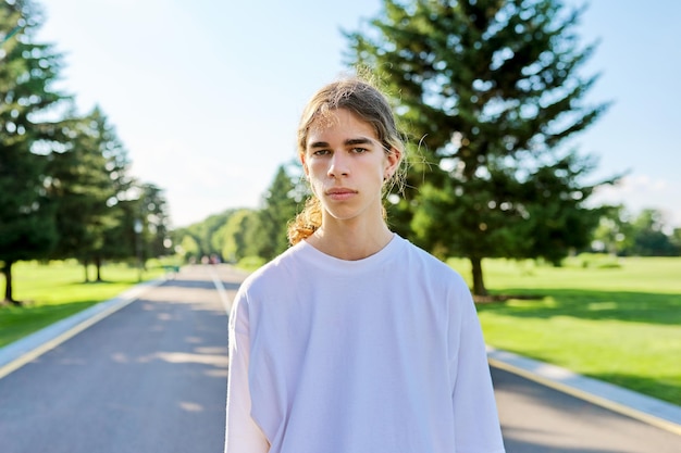 Retrato de un adolescente guapo mirando a la cámara al aire libre