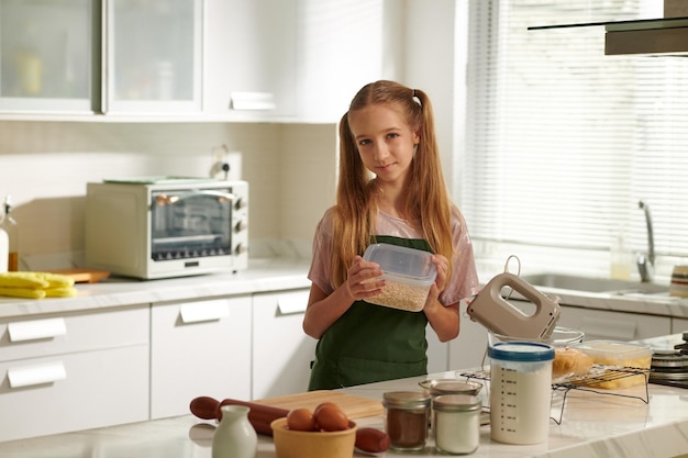 Retrato de una adolescente haciendo masa para galletas en la cocina