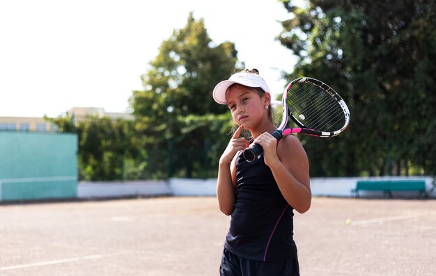 Retrato de una adolescente jugando al tenis en la cancha deportiva