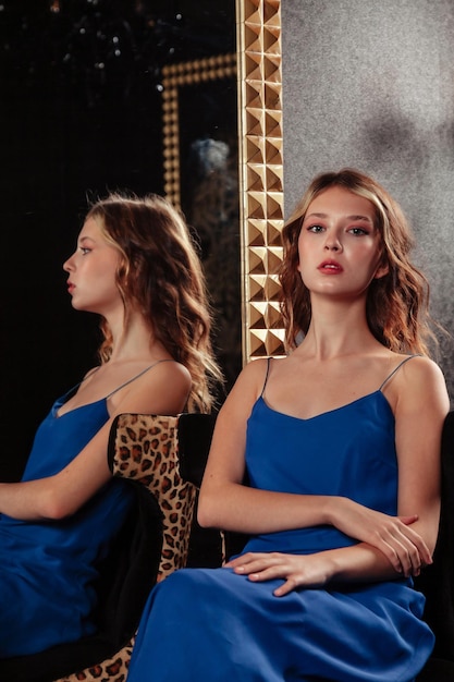 Retrato de una adolescente muy linda con un vestido elegante en el espejo