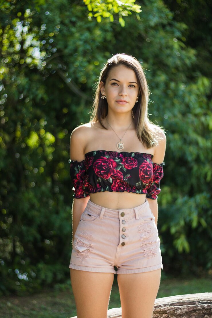 Foto retrato de una adolescente de pie contra los árboles en un parque