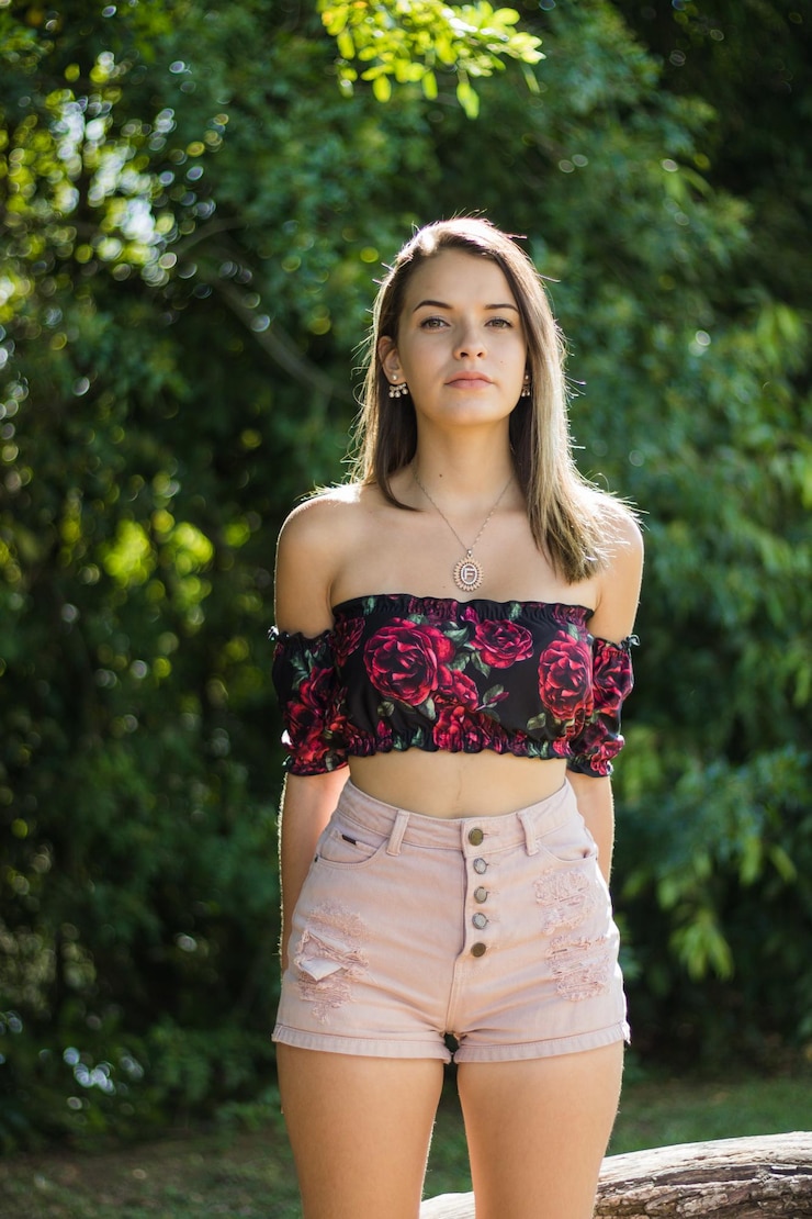 Foto retrato de una adolescente de pie contra los árboles en un parque