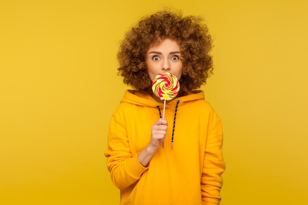 Retrato de una adolescente de pie contra un fondo amarillo