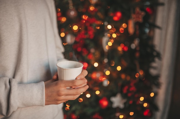 Retrato de un adolescente sincero y auténtico soñador que disfruta de una taza de café caliente por la mañana en casa Navidad