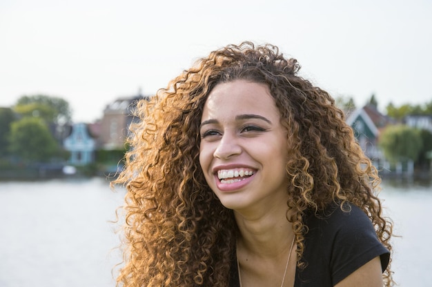 Retrato de una adolescente sonriente con el cabello rizado