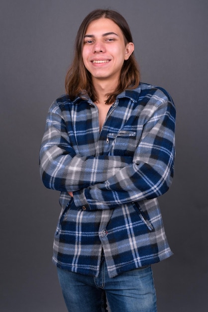 Foto retrato de una adolescente sonriente contra un fondo gris