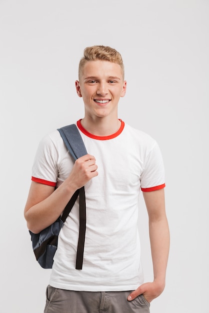 Retrato de un adolescente sonriente de pie con mochila