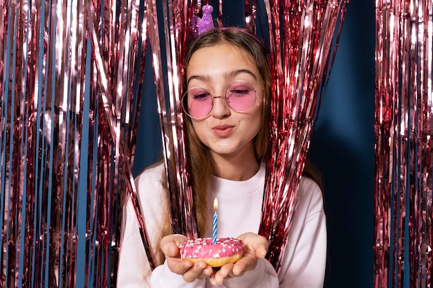 Foto retrato de una adolescente soplando las velas de cumpleaños