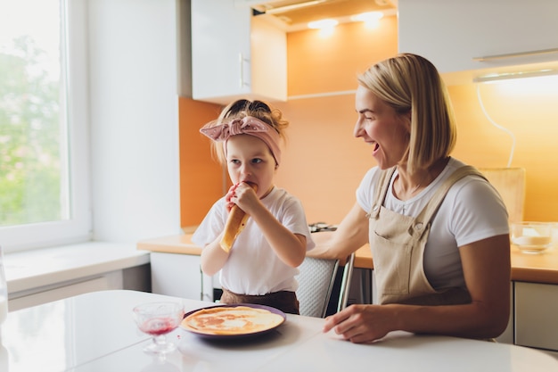 Retrato de una adorable madre e hija preparando a una hija juntos en la cocina.