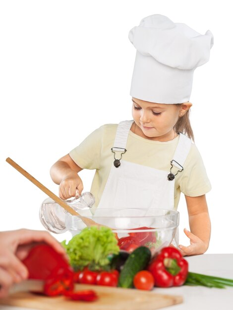 Retrato de adorable niña preparando alimentos saludables en la cocina