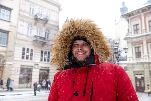 retrato, de, adulto joven, hombre, en, capucha, con, piel, en, invierno, plaza de la ciudad