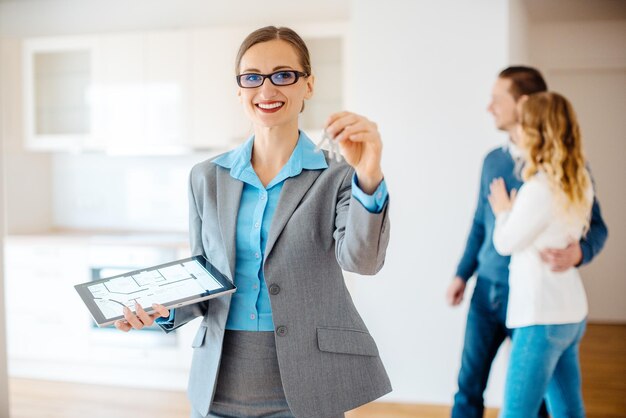 Foto retrato de un agente inmobiliario sonriente con la llave en la mano