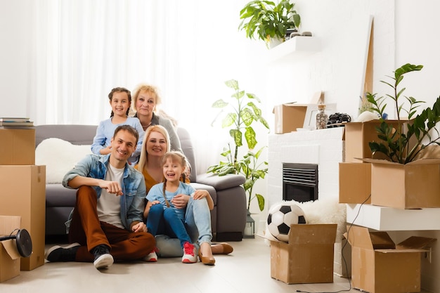 Retrato de agradable atractivo encantador encantador alegre gran familia completa sentada mamá papá haciendo techo nuevo apartamento mover