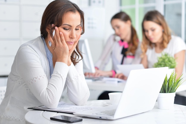 Retrato de una agradable mujer de negocios con una laptop en la oficina