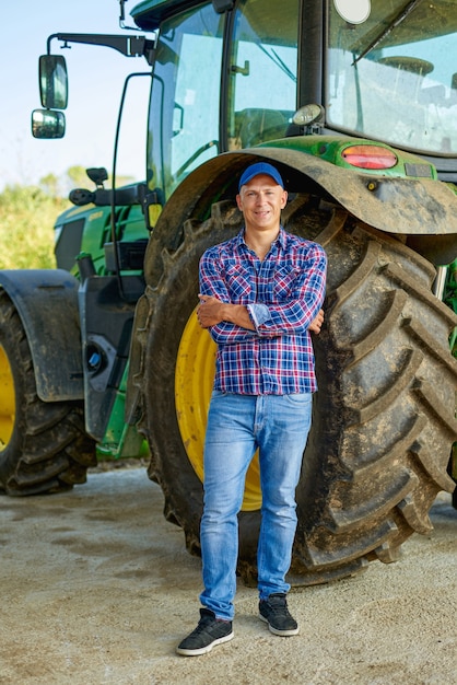 Retrato de agricultor por tractor en campo.