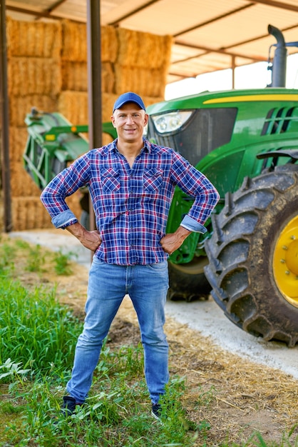 Retrato de agricultor por tractor en campo.