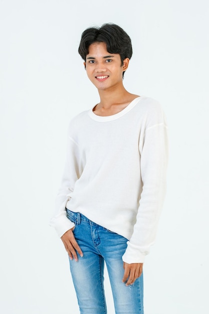 Retrato aislado foto de estudio del joven asiático LGBTQ gay glamour feliz guapo bisexual homosexual hombre modelo de moda en ropa casual de pie recto sonriendo mirar a la cámara sobre fondo blanco
