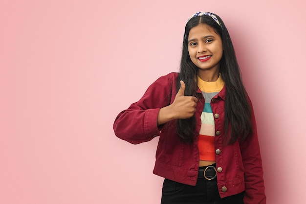 Retrato aislado de una joven india asiática sonriente que muestra los pulgares hacia arriba y el espacio de copia simulado sonriente