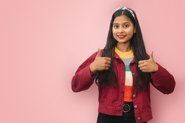 Retrato aislado de una mujer joven asiática india sonriente que muestra los pulgares hacia arriba con espacio para copiar