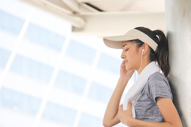 Retrato de ajuste y deportiva mujer asiática joven relajante en la ciudad