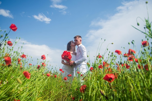 Retrato al aire libre del abrazo de la pareja en las relaciones amorosas del campo de amapolas rojas