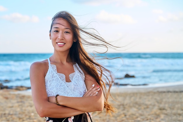 Retrato al aire libre de feliz hermosa mujer joven en el espacio de copia de playa de mar