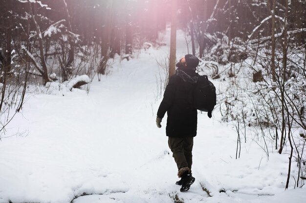 Retrato al aire libre de hombre guapo en abrigo y caspa. Hombre barbudo en el bosque de invierno.