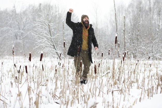 Retrato al aire libre de un hombre guapo con abrigo y caspa. Hombre barbudo en el bosque de invierno.