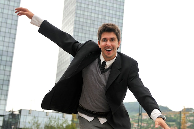 Retrato al aire libre del hombre de negocios joven y feliz