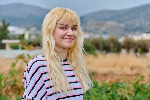 Retrato al aire libre de una joven adolescente sonriente mirando la cámara