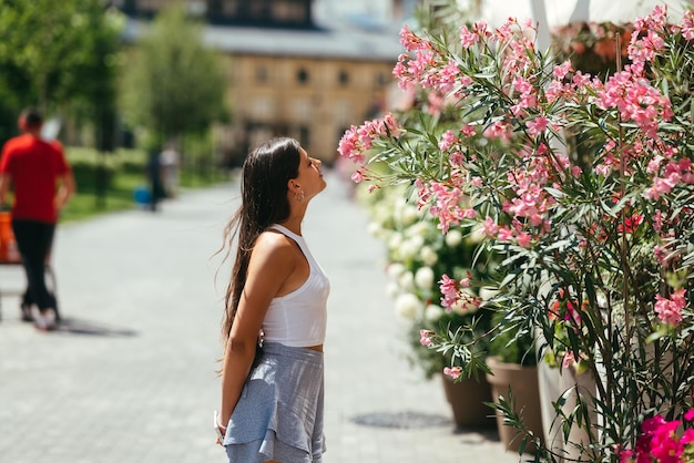 Retrato al aire libre de una joven hermosa dama posando cerca de un árbol en flor