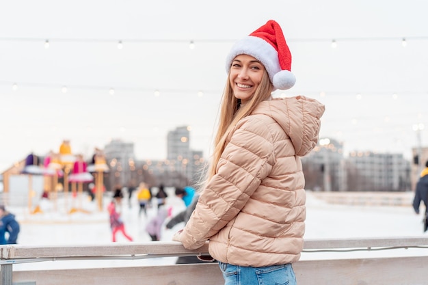 Retrato al aire libre joven hermosa mujer de moda con sombrero de Santa posando calle de la ciudad europea Concepto de vacaciones de Navidad de invierno