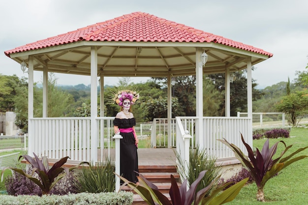 Retrato al aire libre de mujer maquillada como catrina. Mexicana maquillada de catrina para día de muertos