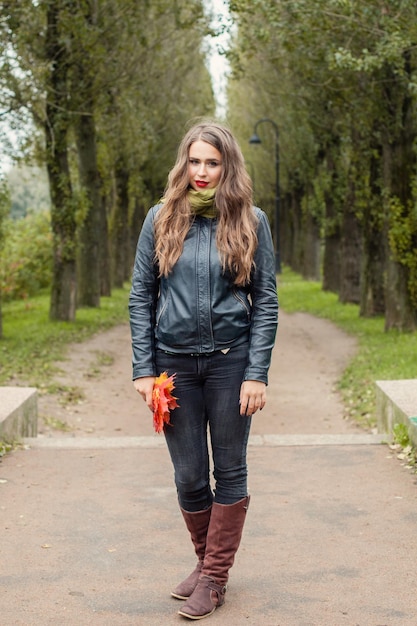 Retrato al aire libre de la mujer del otoño Modelo femenino perfecto que camina en parque del otoño