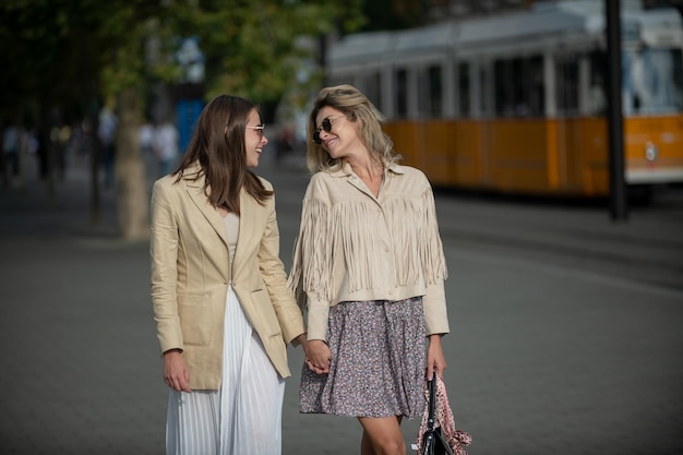 Retrato al aire libre de mujeres jóvenes caucásicas felices disfrutando de un buen día Chicas jóvenes bonitas divirtiéndose juntas al aire libre Estilo de vida urbano Mejores amigas con ropa informal