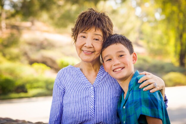 Retrato al aire libre de un niño biracial chino y caucásico y su abuela china