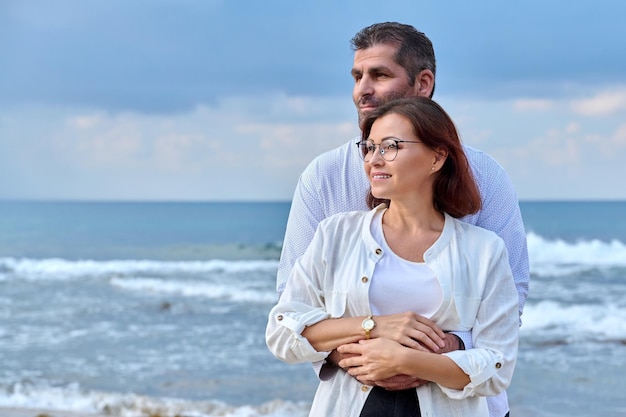 Retrato al aire libre de una pareja madura abrazándose en el espacio de copia de la orilla del mar