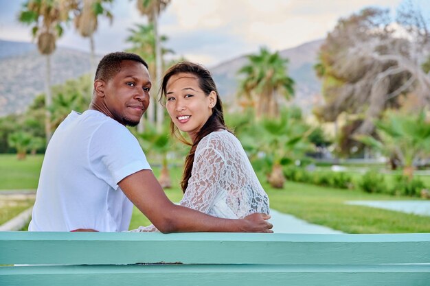 Retrato al aire libre de una pareja multirracial abrazándose juntos