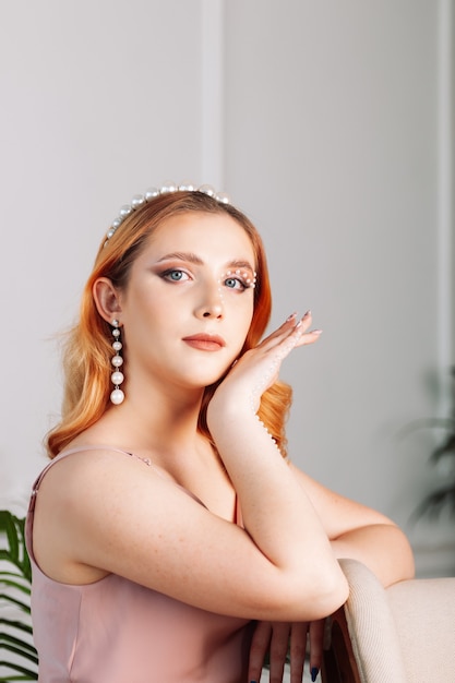 Retrato al lado de una mujer de rostro pálido con cabello ondulado con perlas en el rostro y una mano en su ...